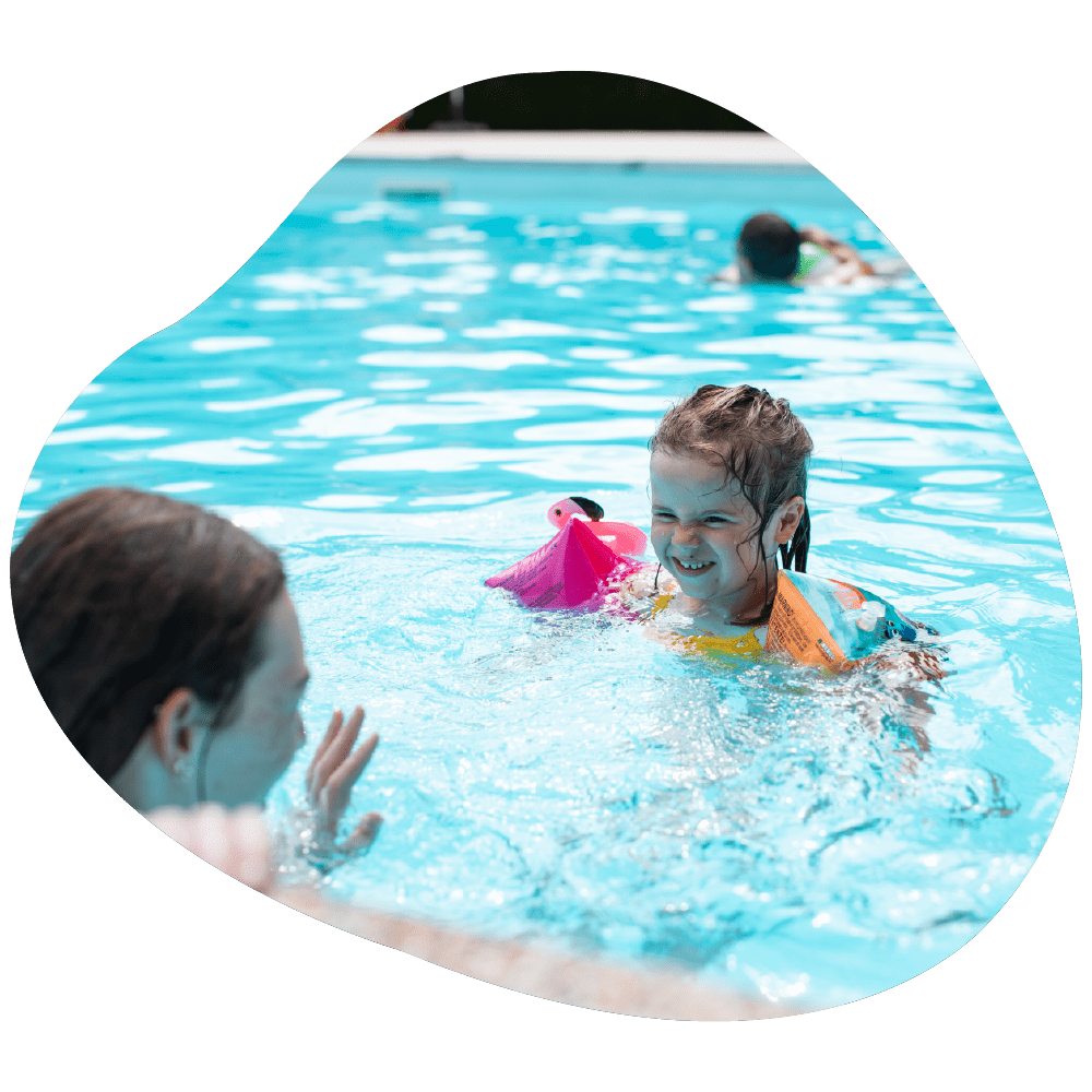 Enfants et parents dans la piscine extérieur du camping à Ispagnac