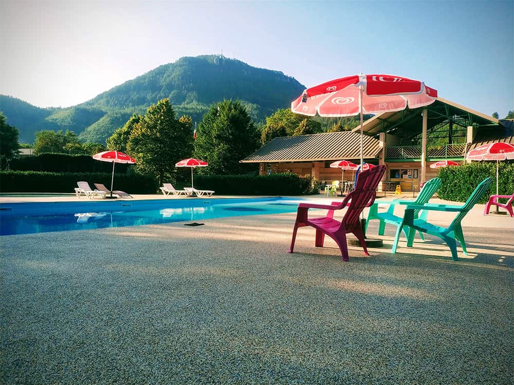 Espace de détente autour d'une piscine dans le camping Le Pré Morjal